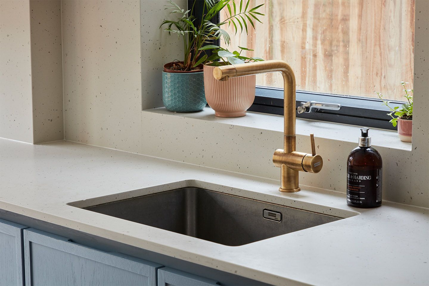 Close up of Caesarstone Frozen Terra worktop with a brass Franke tap