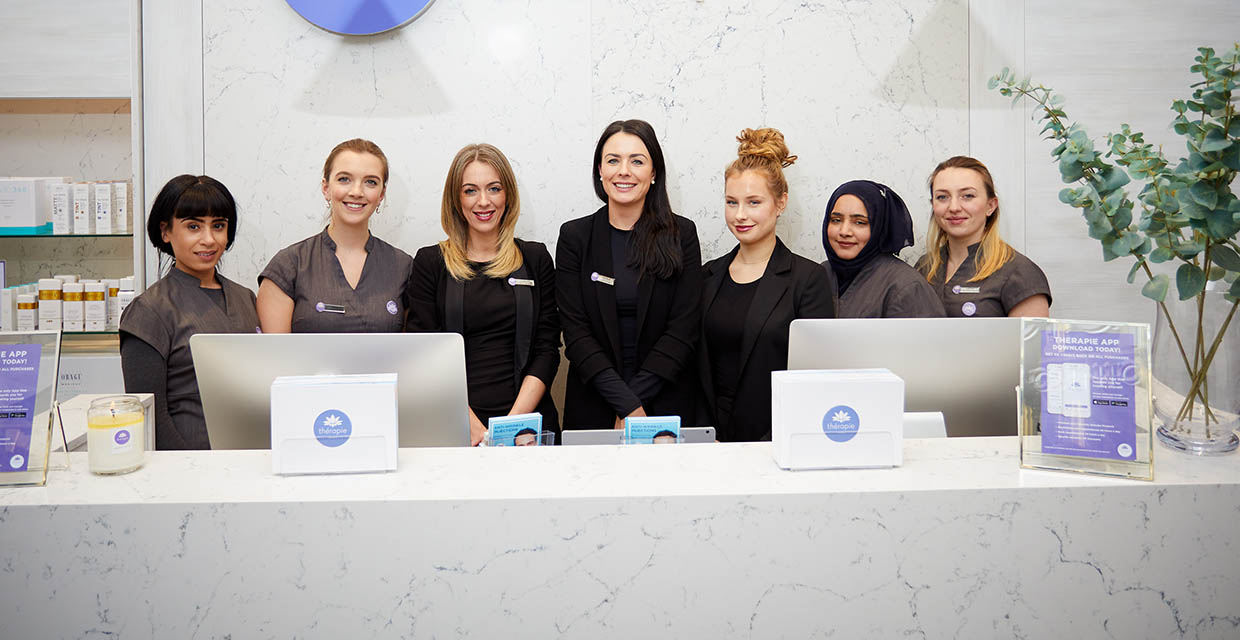 a group of women standing behind reception counter